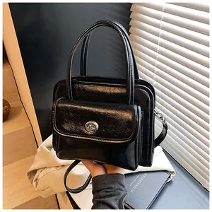 Detail of black glossy synthetic leather bowling bag with silver metal twist lock