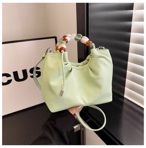 Détail du sac nuage plissé vert menthe avec poignée décorative en perles colorées