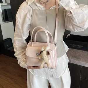 Pink glossy patent leather bowling bag with silver twist lock and plush puppy charm