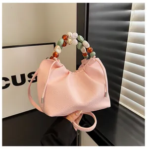 Détail du sac nuage rose avec poignée en perles colorées et cordon de serrage décoratif