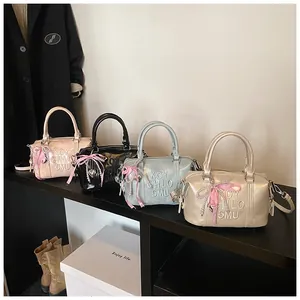 Detail of Boston bags in four colors with pearl charms and silk bows in a lifestyle setting