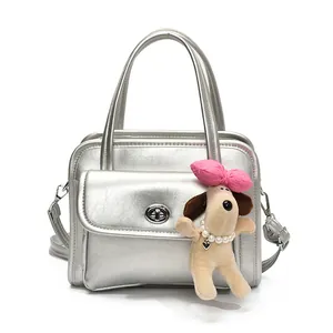 Silver metallic bowling handbag with crossbody strap and cute plush puppy charm