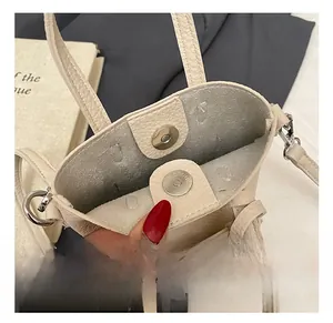 Vista dettagliata della mini borsa a tracolla color crema in pelle con chiusura magnetica