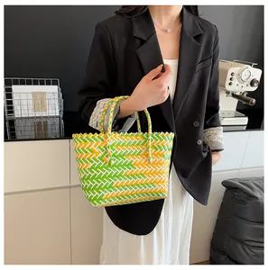 Détail du sac cabas tissé coloré avec motif à carreaux vert, jaune, blanc et anse