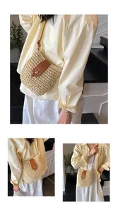 Detail of hand-woven straw bucket bag with brown leather flap and brass buckle closure