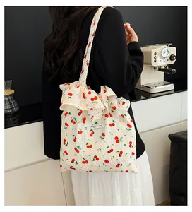 Détail du sac bandoulière blanc à imprimé cerise avec volants et tissu texturé