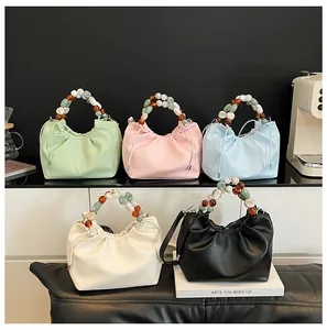 Détail de sacs nuages plissés colorés avec des poignées décoratives en perles marbrées
