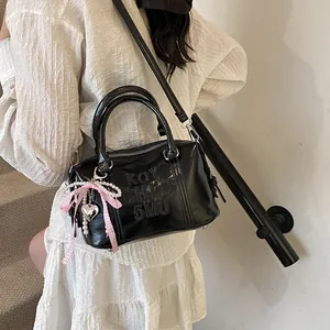 Glossy black Boston bag with embossed letters and pink bow charm for women's fashion