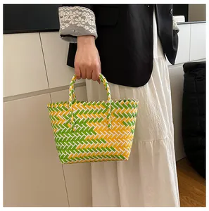 Détail du sac cabas tressé à carreaux vert et jaune avec doubles anses robustes