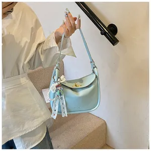 Detailed view of light blue lychee pattern hobo bag with gold twist lock and charm