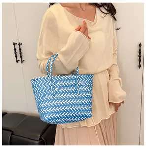 Détail du sac cabas tissé à la main à carreaux bleu et blanc avec poignées tissées