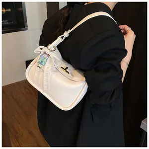 Detail of white litchi pattern leather underarm bag with gold twist lock and lace bow