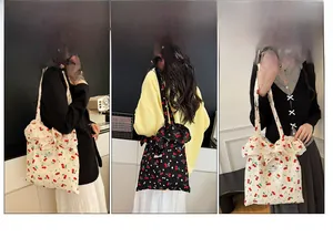 Détail d'un sac cabas en toile avec imprimé cerise et grand nœud décoratif latéral