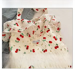 Détail du tissu texturé à imprimé cerise blanc avec volants et étiquette Magic Pocket