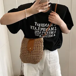 Handwoven straw bucket bag with dark brown leather flap and long crossbody strap