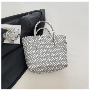 Vue détaillée du motif tressé gris et blanc sur un grand sac cabas type panier
