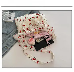 Intérieur spacieux d'un sac cabas à motif cerise contenant tablette et accessoires