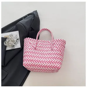 Détail du sac cabas tressé à carreaux rose et blanc avec anses doubles robustes