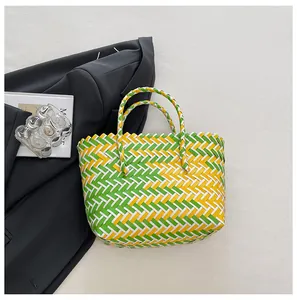 Détail macro d'un sac cabas tissé coloré avec des motifs à carreaux vert, jaune et blanc