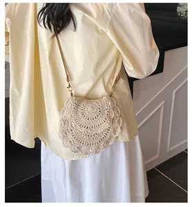 Détail du sac bandoulière tissé crème avec dentelle ajourée et crochet métallique