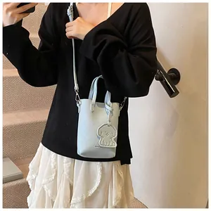 Dettaglio della mini borsa azzurra con trama litchi e ciondolo a forma di cane