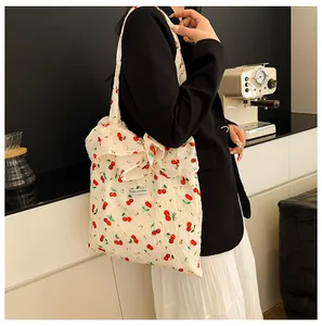 Détail du cabas blanc à motif cerises orné d'un grand nœud décoratif élégant et chic