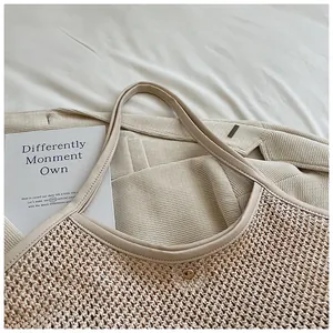 Detailed close-up of a woven mesh beach tote featuring beige PU trim and a gold metal snap