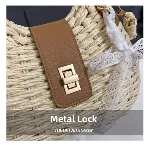 Detail of golden metal rotary hardware clasp on a woven straw bag with lace and leather accents