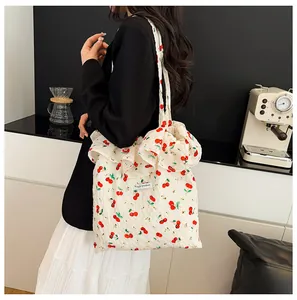 Détail du sac cabas à imprimé cerise avec bords à volants et étiquette Magic Pocket