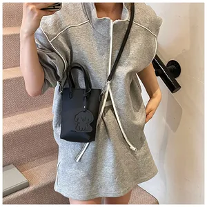 Selfie allo specchio che mostra le dimensioni della mini borsa nera a tracolla con charm a cane