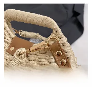 Detailed macro view of golden metal hook and woven straw texture on beach bag