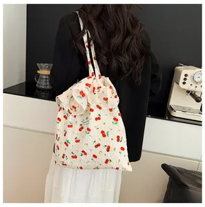 Détail du sac cabas en toile fleurie avec bords volantés et imprimé cerises