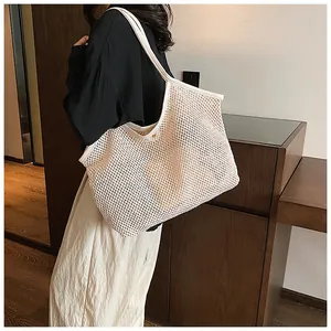 Detail of hollow mesh tote bag showing magnetic snap closure and woven texture