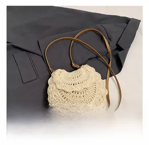 Détail du sac à bandoulière tressé crème avec texture florale et lanière en cuir