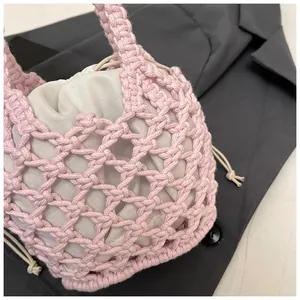Détail du sac à main tricoté rose avec maille diamant évidée et pochette intérieure crème