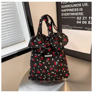 Détail du sac cabas en toile fleurie avec motifs cerises et bords à volants décoratifs