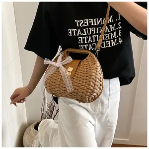 Detailed close-up of handmade straw bag with leather buckle and white lace bow accessory