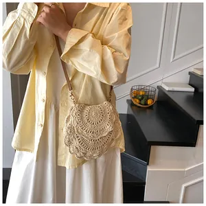 Détail du motif ajouré au crochet sur ce sac bandoulière tissé crème avec sangle en cuir