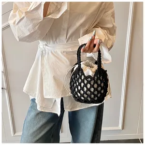 Détail du sac à main en maille noire tissé à la main avec une pochette blanche contrastée