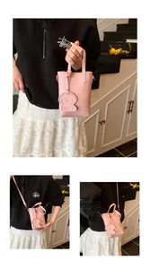 Mini borsa rosa trama litchi con ciondolo a barboncino e tracolla regolabile