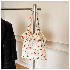 Vue détaillée du sac cabas à imprimé cerise avec bords à volants et texture matelassée