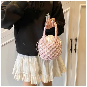 Gros plan du sac à main tissé rose avec doublure en satin et poignée circulaire rigide