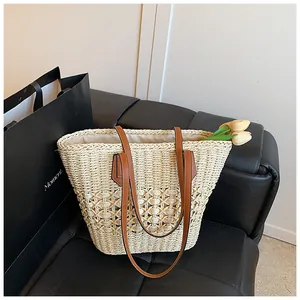 Detail of hollow diamond weave pattern on beige straw tote bag with brown leather straps