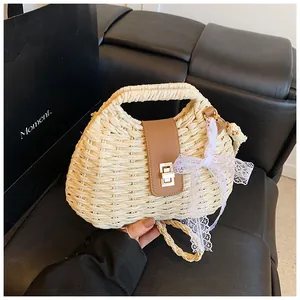 Detail of hand-woven straw bag featuring leather flap, metal lock, and lace bow detail