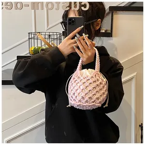 Détail d'un sac seau rose crocheté à la main avec doublure intérieure à cordon crème