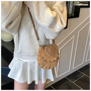 Gros plan sur un sac à bandoulière en paille tressée à la main avec rabat festonné