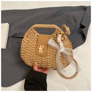 Detail of hand-woven straw bag with leather flap, gold metal lock and lace bow charm