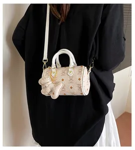 Detail of Boston bag showing lychee grain texture and bear pattern with gold hardware