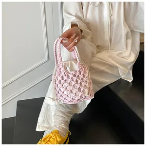 Gros plan du sac seau rose tissé à la main avec doublure blanche sur le mannequin