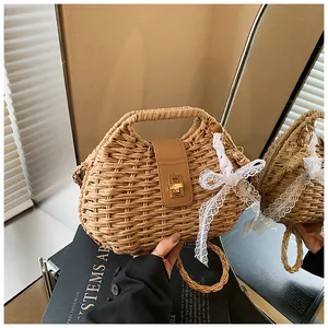 Detail of straw woven bag with leather flap, gold twist lock and white lace bow